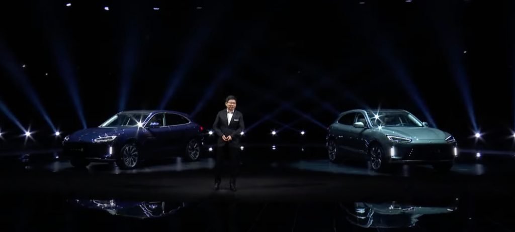 Richard Yu, CEO da divisão de carros inteligentes da Huawei, durante apresentação da empresa; ao lado esquerdo e direito do executivo aparecem dois carros elétricos Aito M5 da empresa