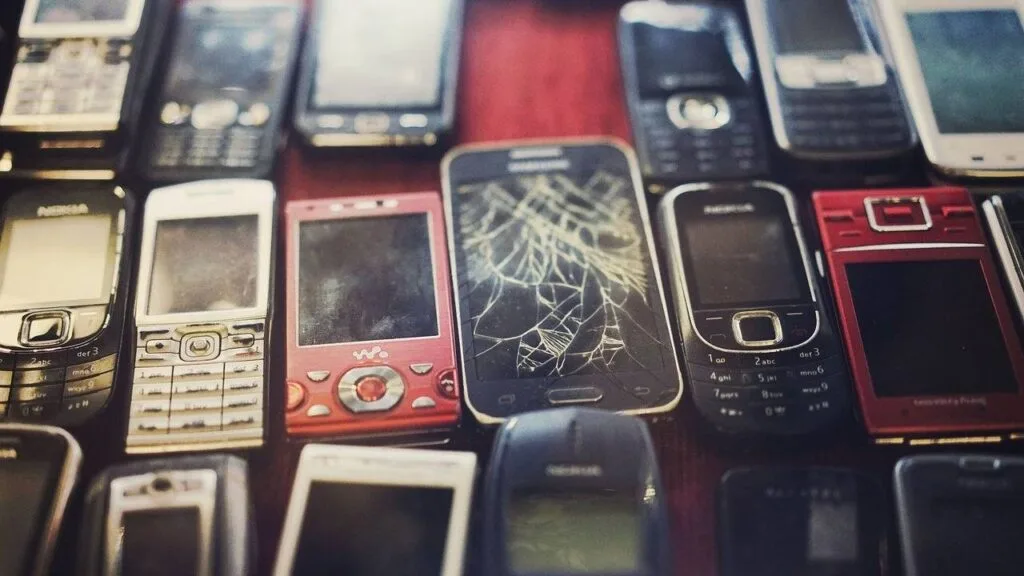 Imagem mostra celulares descartados, um tipo comum de lixo eletrônico que a economia circular visa reduzir