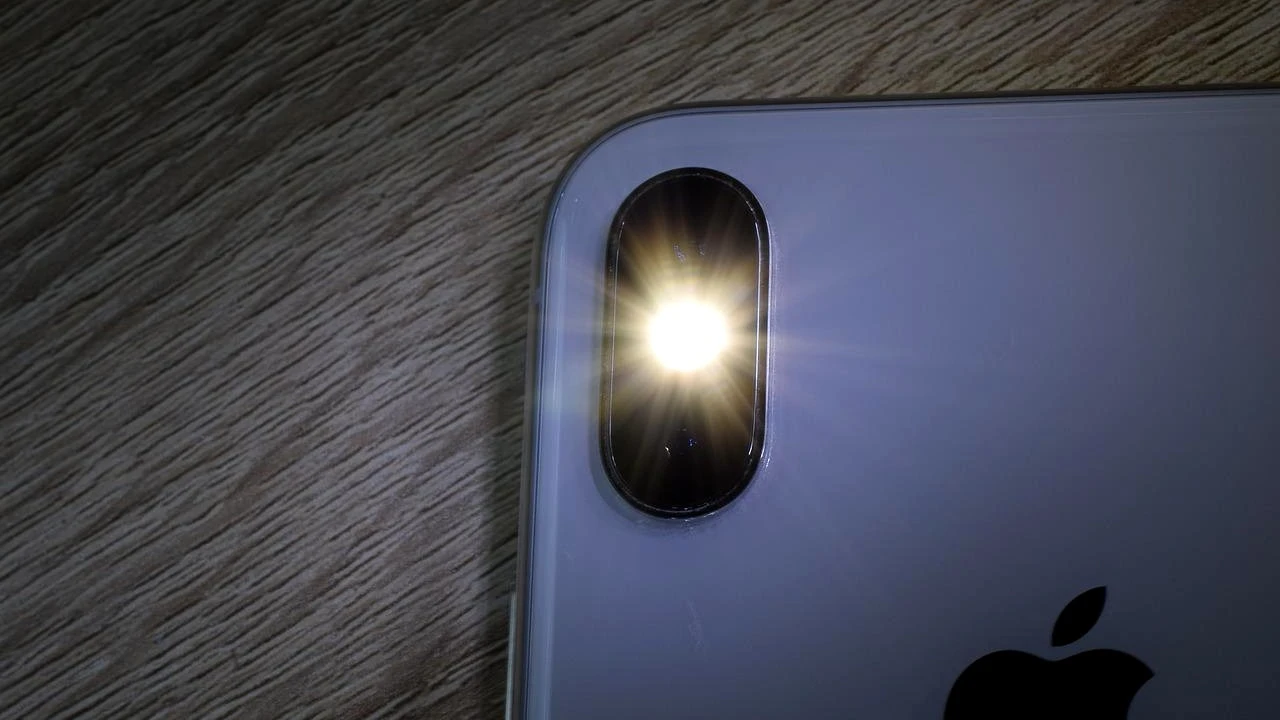 Na foto aparece a traseira de um iPhone com o flash da câmera ligado