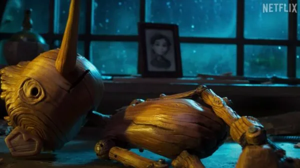 Cena de Pinóquio, animação criada por Guillerme Del Toro e publicada na Netflix; na imagem aparece o menino de madeira deitado ao lado de uma janela